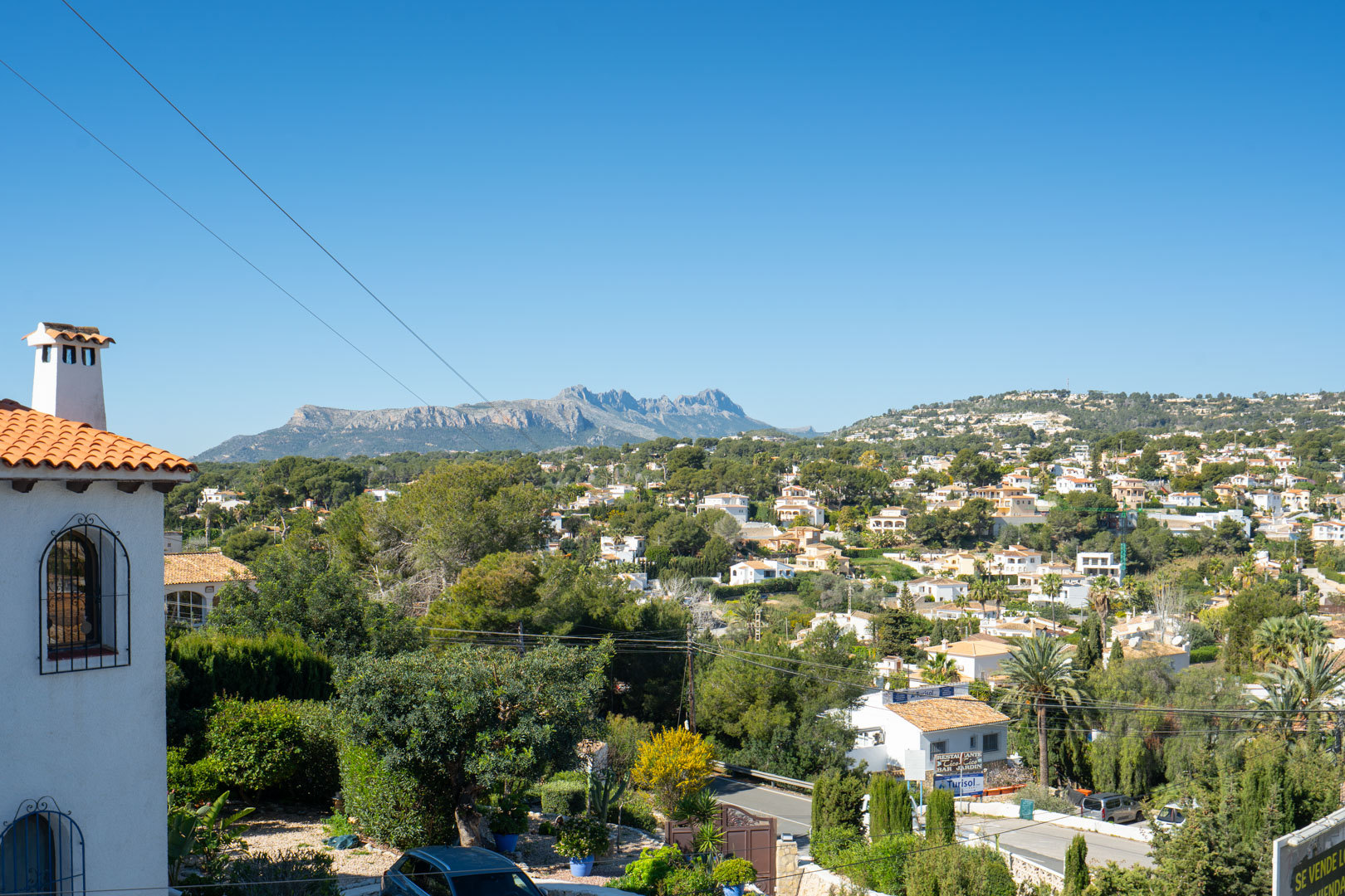 Vistas despejadas desde la terraza superior hacia la Sierra de Bernia, capturando el entorno residencial rodeado de vegetación mediterránea y montañas.