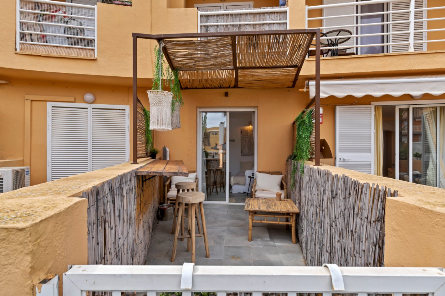 Terraza privada con barra de madera y toldo de brezo, ideal para el exterior.