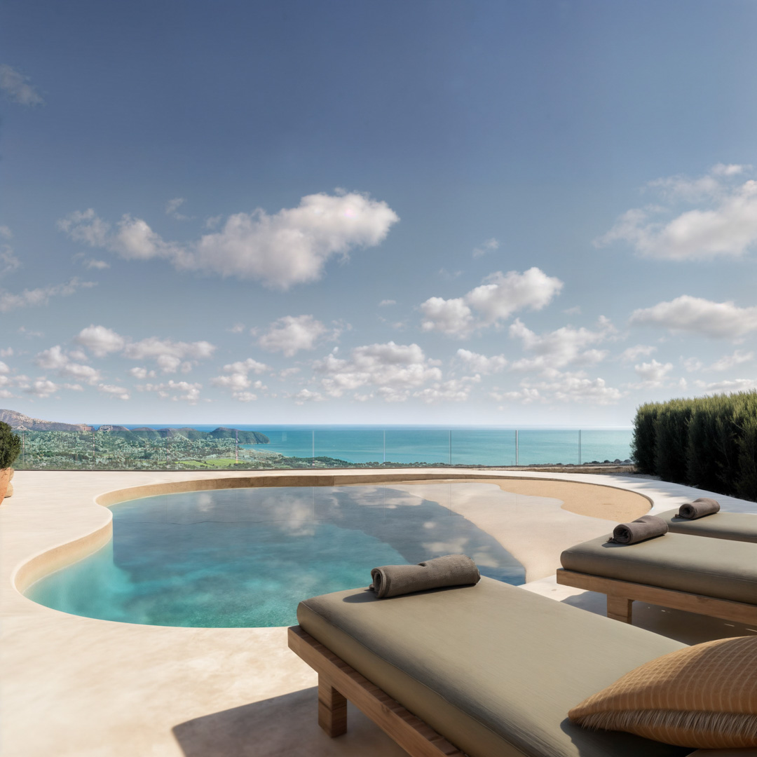 Terraza con piscina de formas orgánicas, pavimento de microcemento y tumbonas de madera con vistas panorámicas al mar Mediterráneo y la costa.