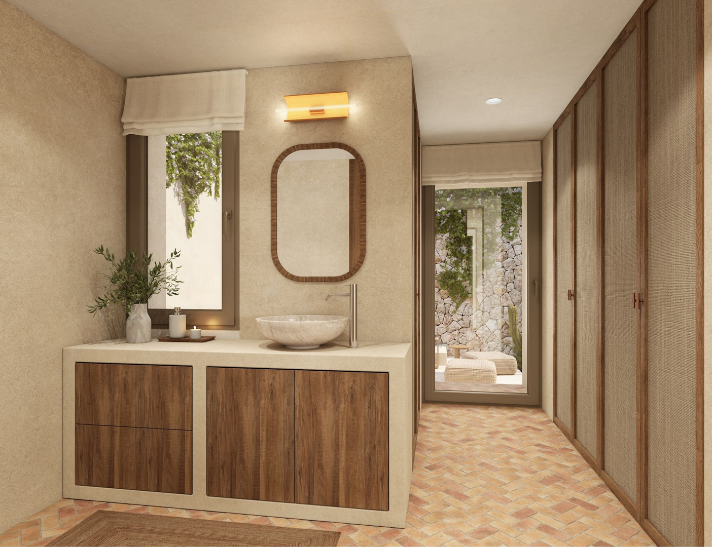Baño con lavabo de piedra, carpintería de madera y suelos de barro en espiga. Incluye armarios empotrados con paneles textiles y acceso directo a un patio privado con muros de piedra.