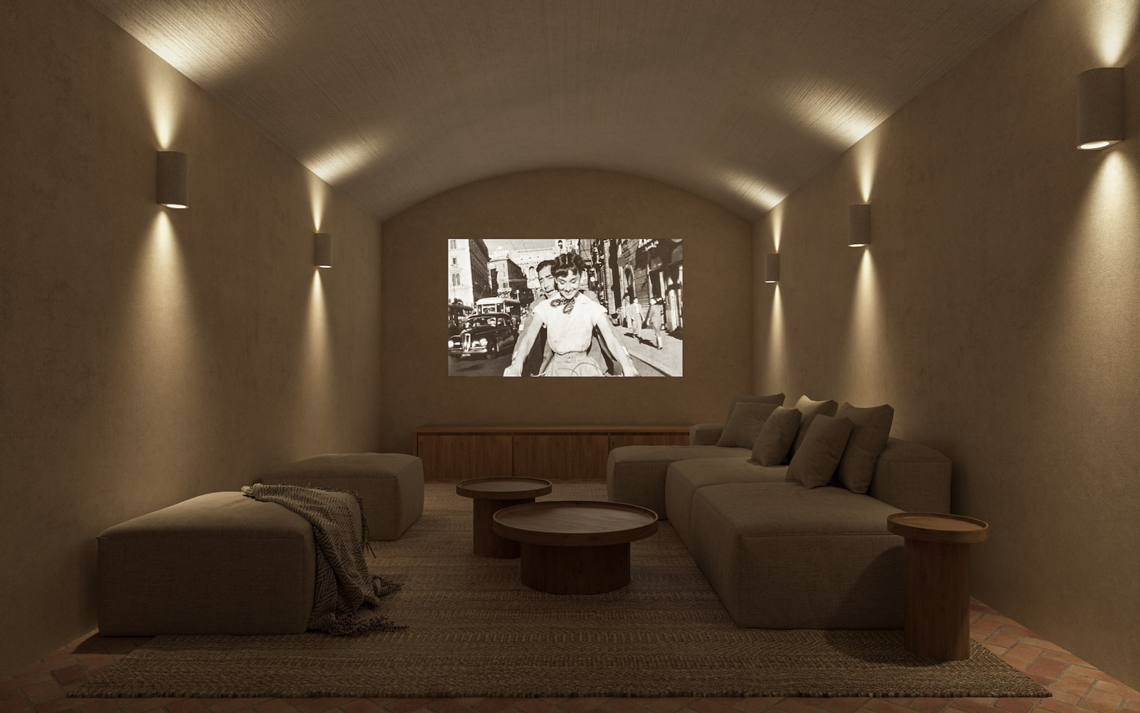 Sala de cine privada con techo abovedado, paredes de yeso texturizado y apliques bidireccionales. Incluye sofás modulares, mesas de madera y suelo de terracota tradicional.