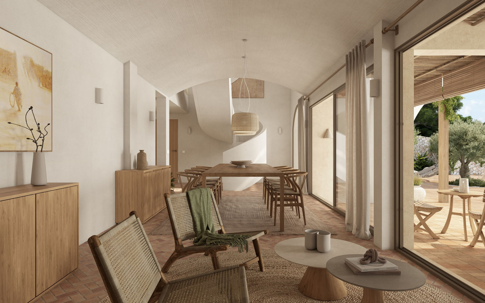 Salón-comedor de concepto abierto con techos abovedados, suelos de terracota y una escalera escultural. Grandes ventanales integran el interior con la terraza y el jardín mediterráneo.