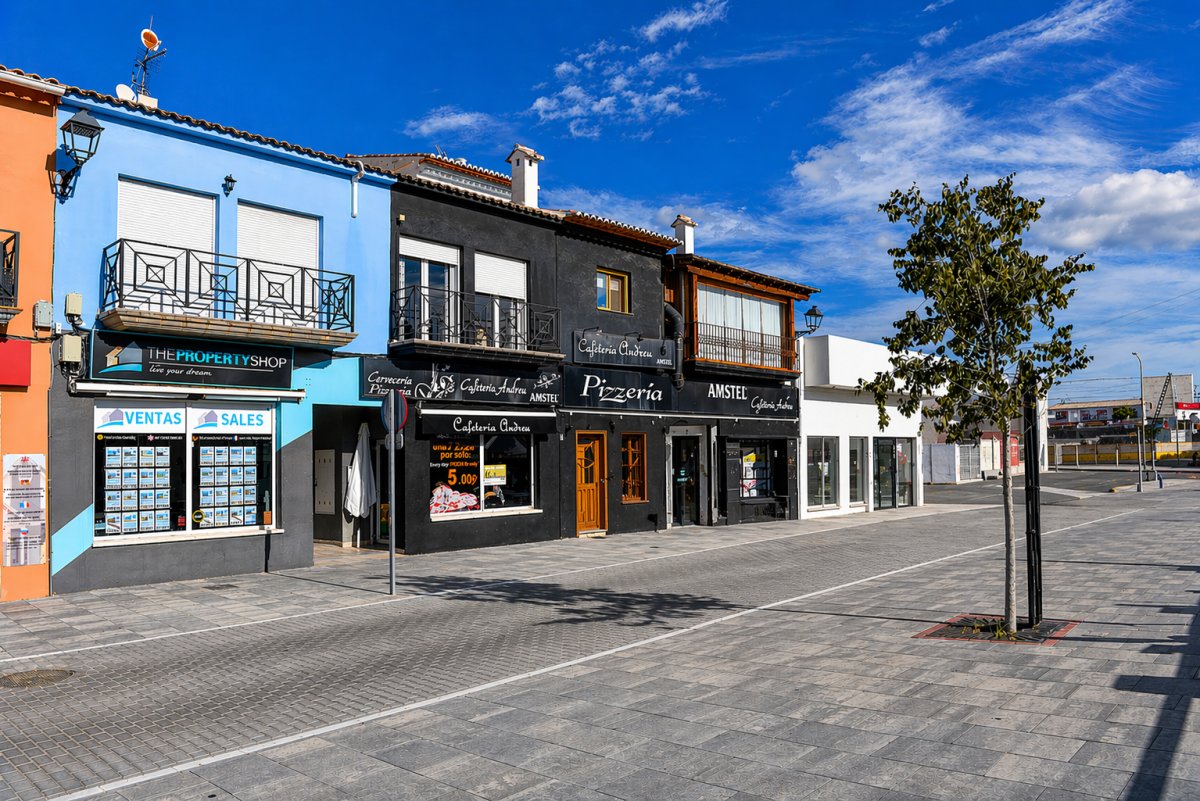 Fachadas coloridas de locales comerciales en Els Poblets, con balcones de hierro forjado y toldos. Fachadas coloridas de locales comerciales en Els Poblets, con balcones de hierro forjado y toldos.