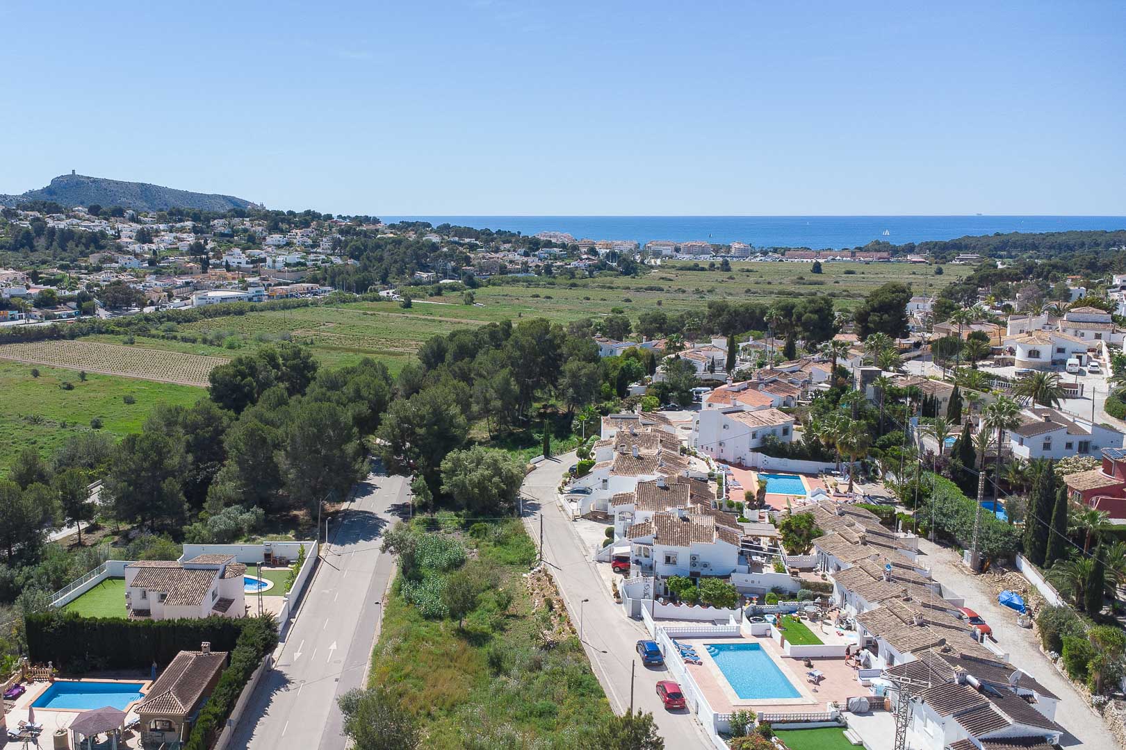 Vista aérea panorámica de Moraira que muestra la proximidad al mar Mediterráneo, rodeada de zonas verdes y la arquitectura residencial de la Costa Blanca.