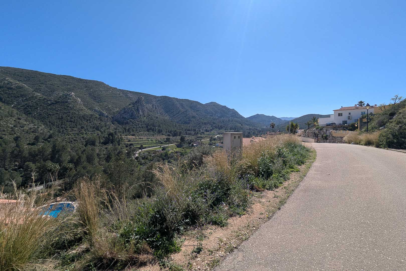 Vistas panorámicas desde el acceso a la propiedad hacia el valle y las montañas circundantes de Pedreguer bajo un cielo despejado.
