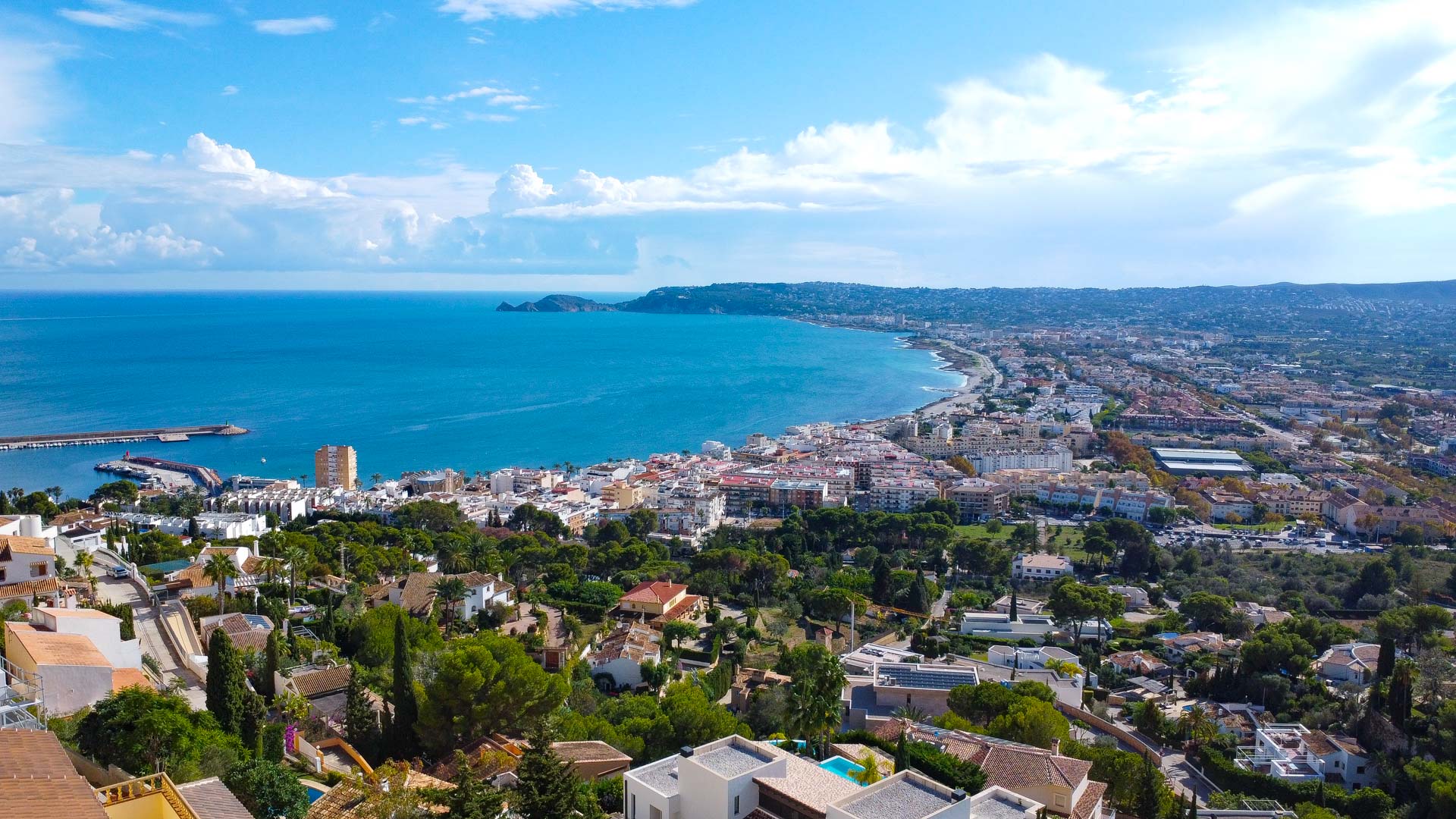 Vistas panorámicas ininterrumpidas de la bahía de Jávea y el puerto desde la urbanización La Corona, destacando la costa mediterránea y el horizonte marino.