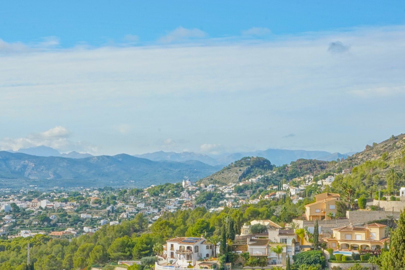 Vista panorámica desde la propiedad hacia el valle y las montañas circundantes, destacando la vegetación mediterránea y el entorno residencial de Jávea.