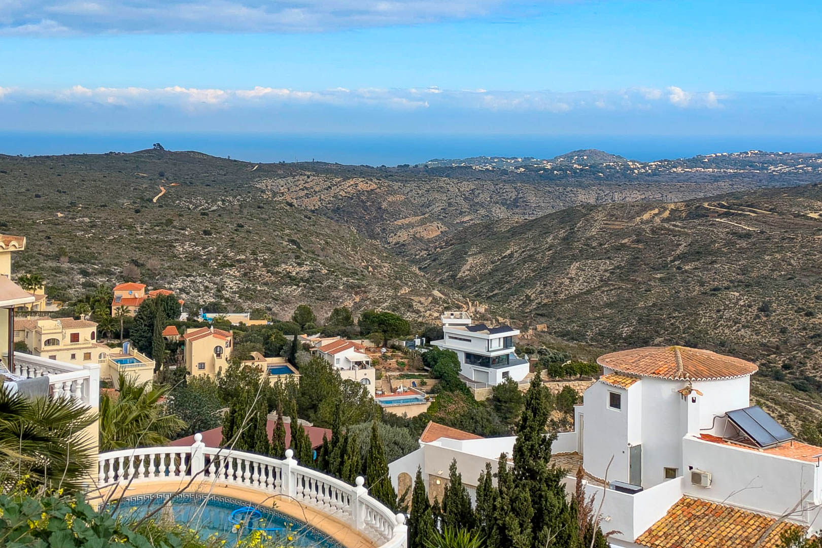 Vista panorámica desde Cumbre del Sol hacia el mar Mediterráneo, mostrando el relieve montañoso y las villas integradas en el entorno natural de Benitachell.