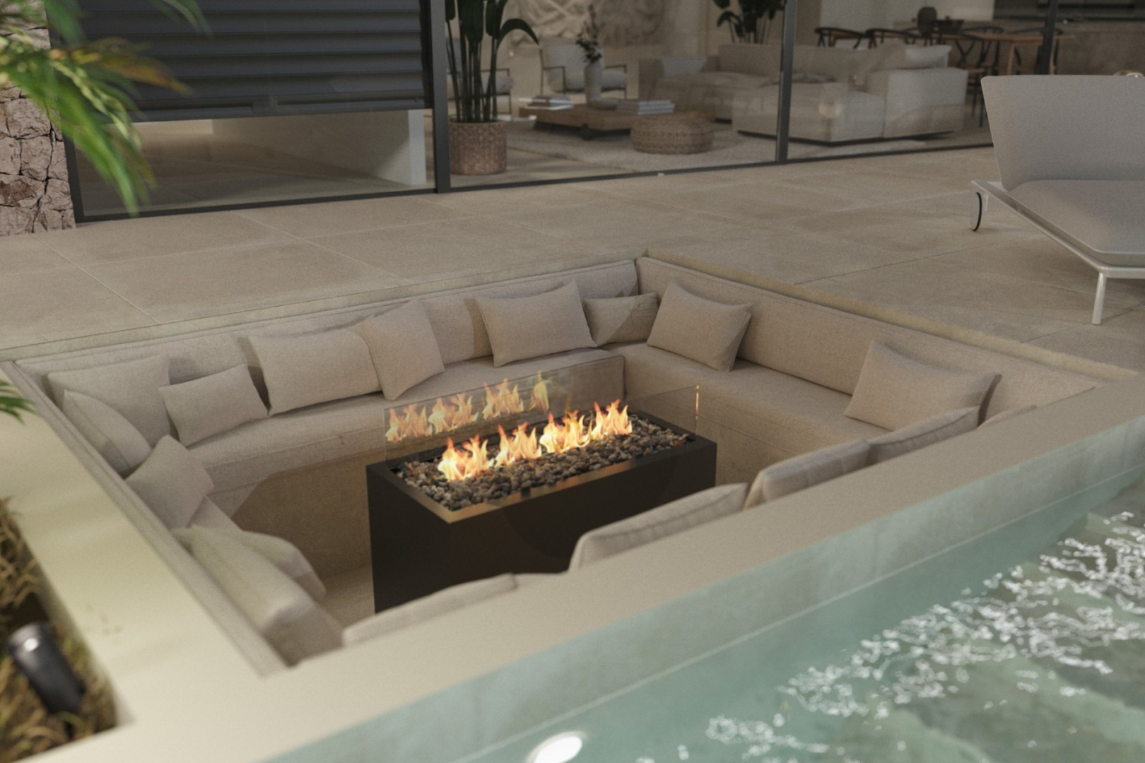 Zona de estar hundida en la terraza con chimenea de gas central y sofás integrados, situada junto a la piscina y conectada al salón principal.