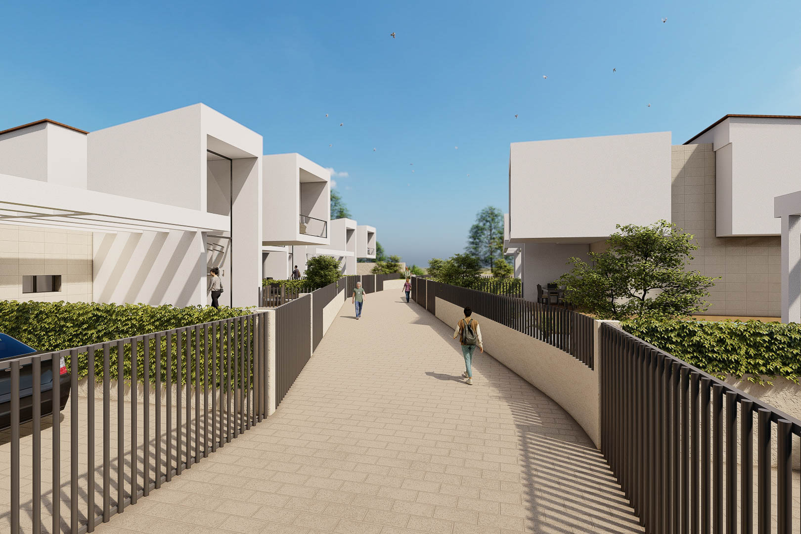 Vista exterior del complejo con villas blancas de diseño cúbico, vallas metálicas oscuras y un camino pavimentado rodeado de vegetación.