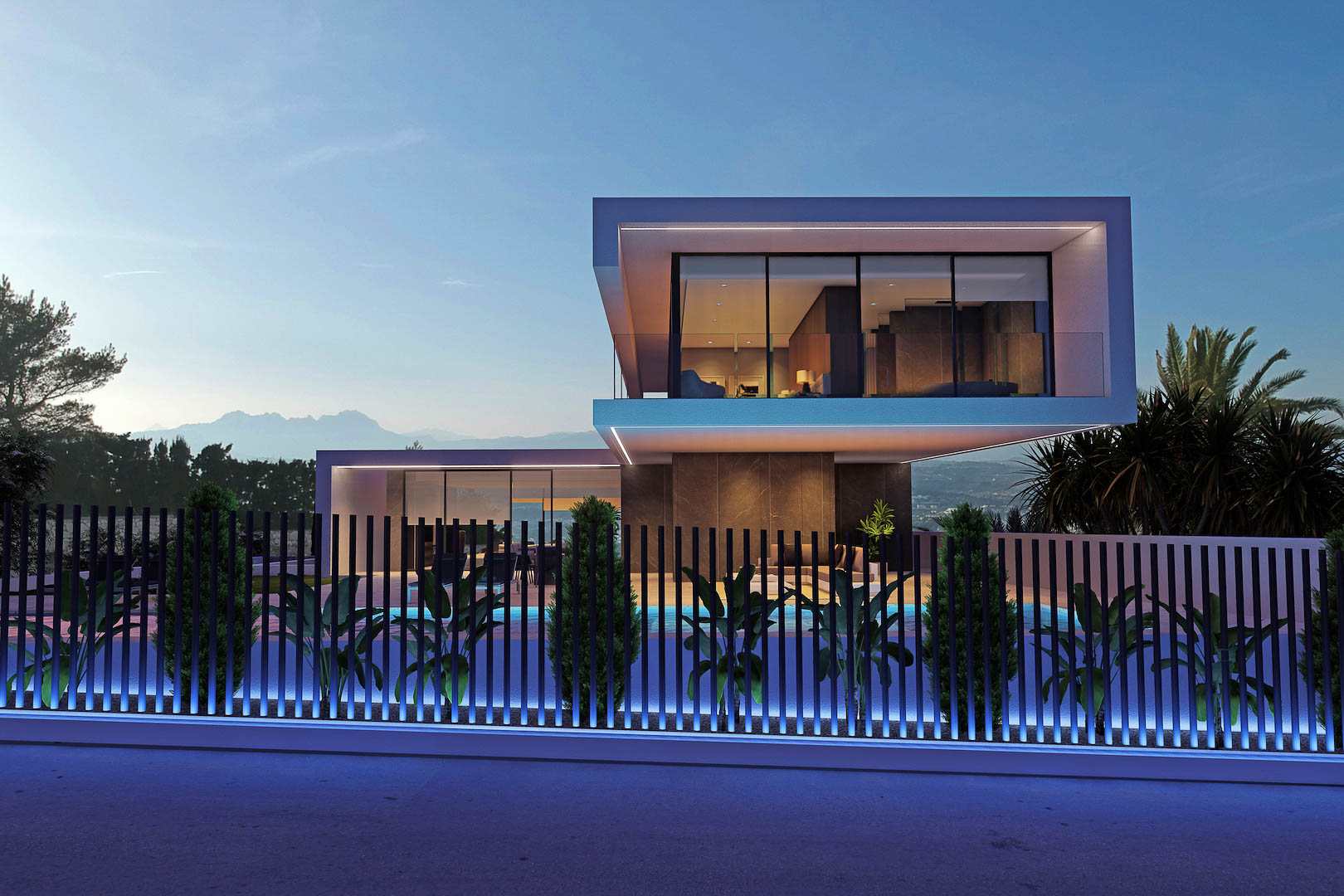 Vista exterior nocturna de la villa, con valla iluminada y piscina visible.