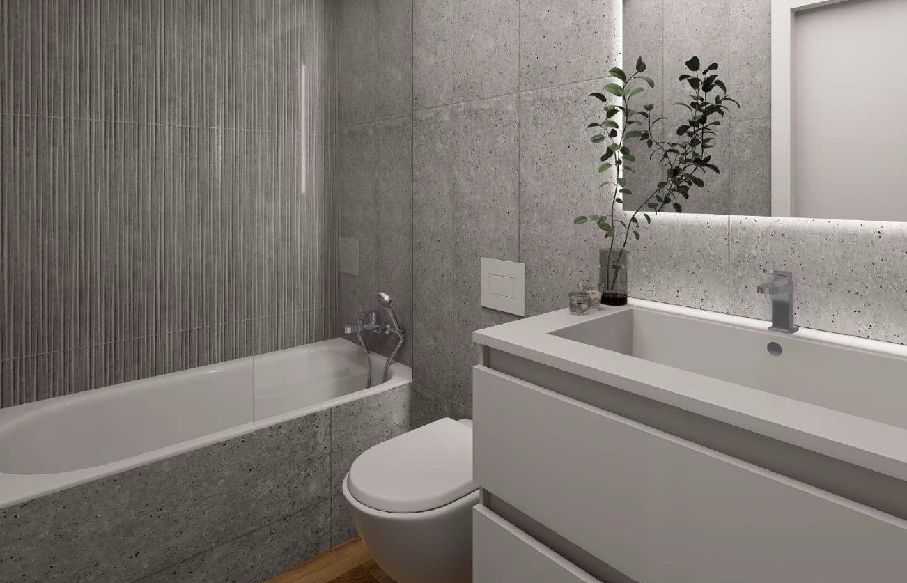 Baño contemporáneo con revestimientos de Porcelanosa en tonos grises, bañera integrada con mampara de cristal y lavabo de diseño con espejo retroiluminado.