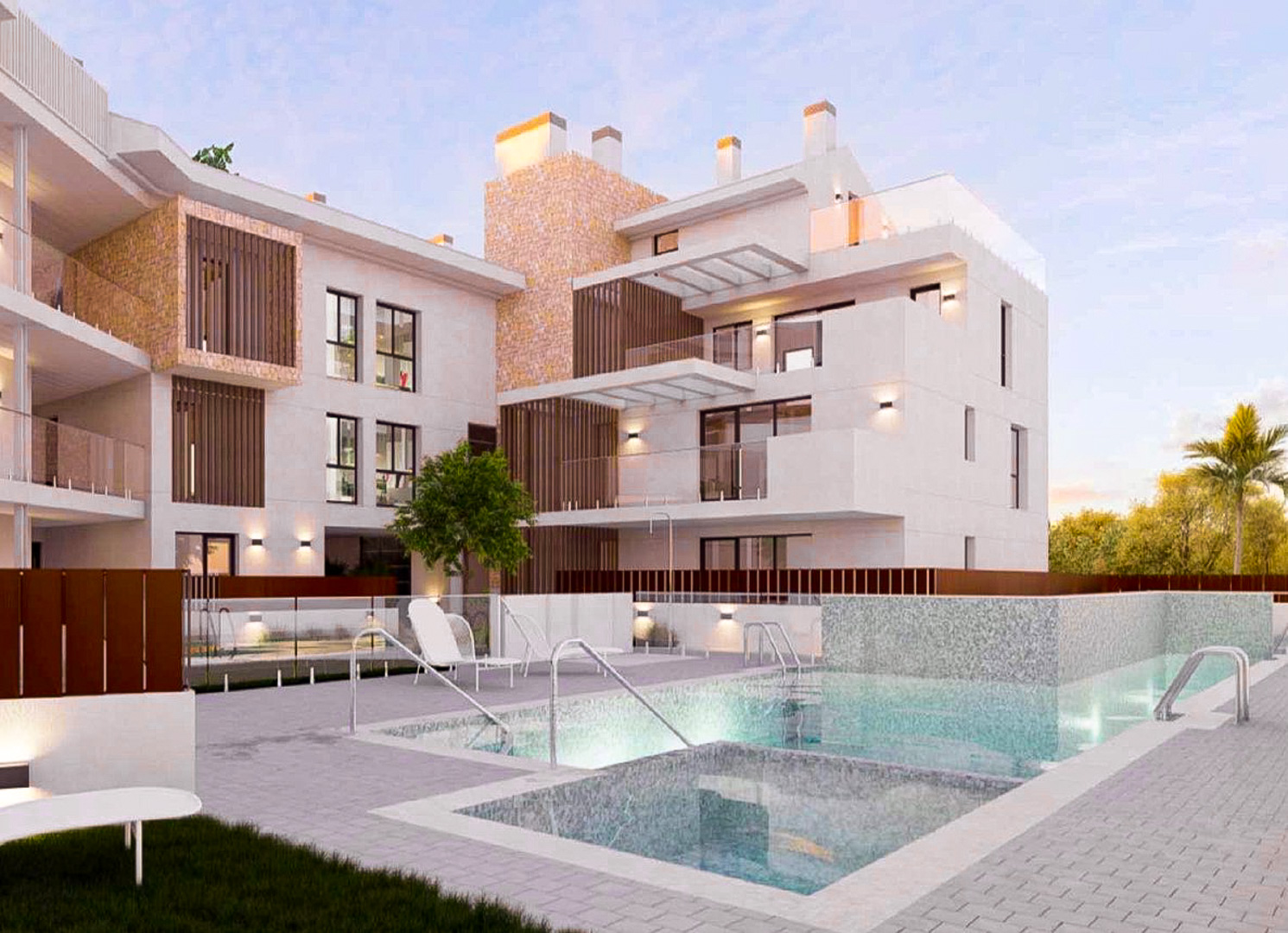 Vista exterior del complejo con piscina comunitaria iluminada, fachadas blancas con detalles de piedra natural y amplias terrazas con barandillas de cristal.