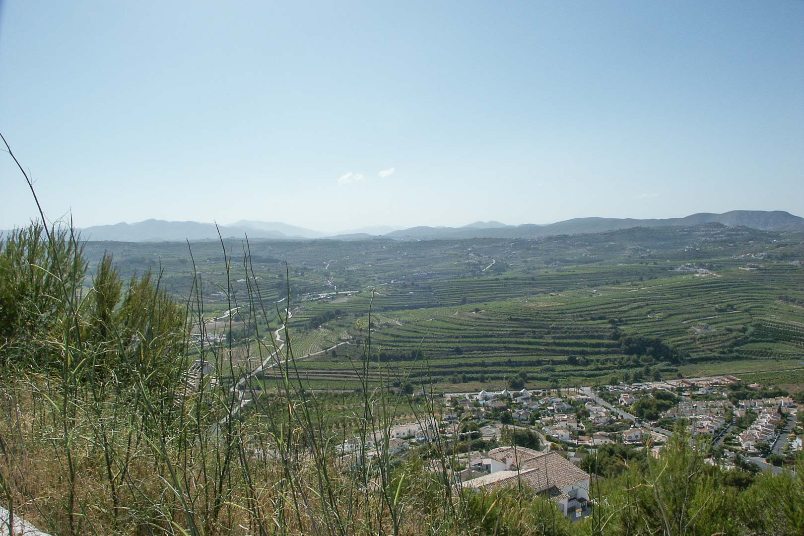 Vista panorámica desde la parcela elevada en Paichi, mostrando los campos aterrazados y las montañas circundantes bajo un cielo despejado.