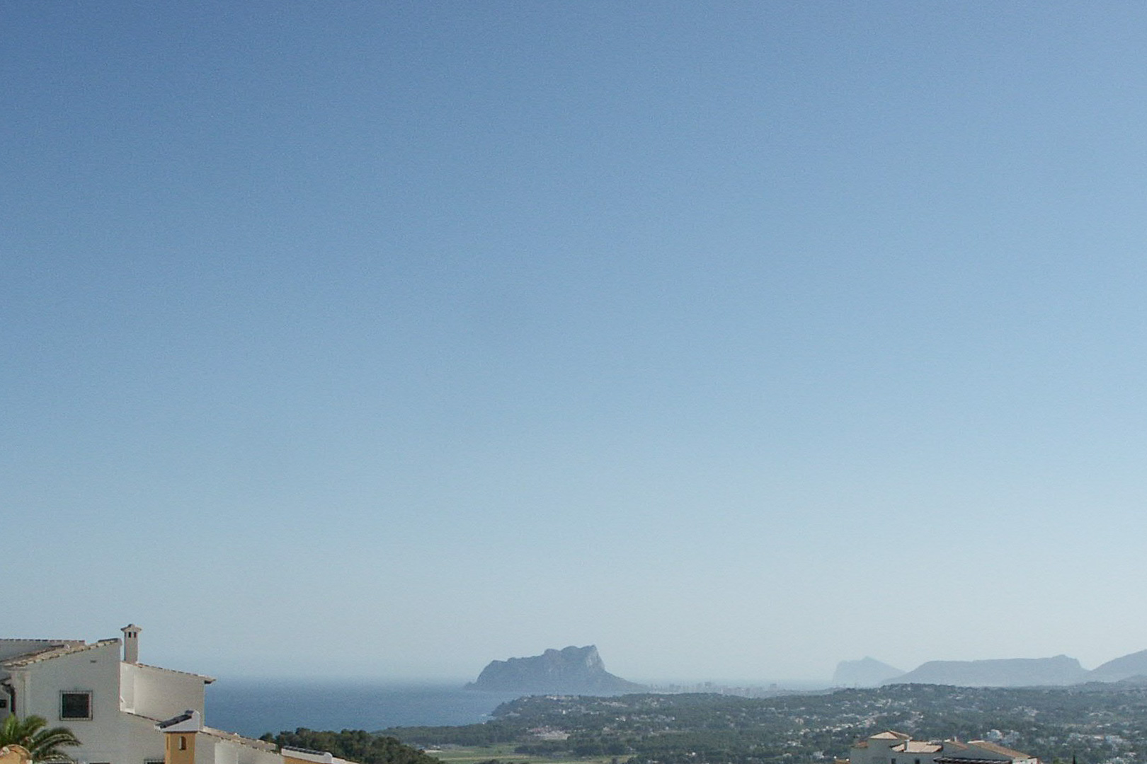 Vista panorámica desde la parcela hacia la costa de Calpe, destacando la silueta del Peñón de Ifach sobre el mar Mediterráneo.