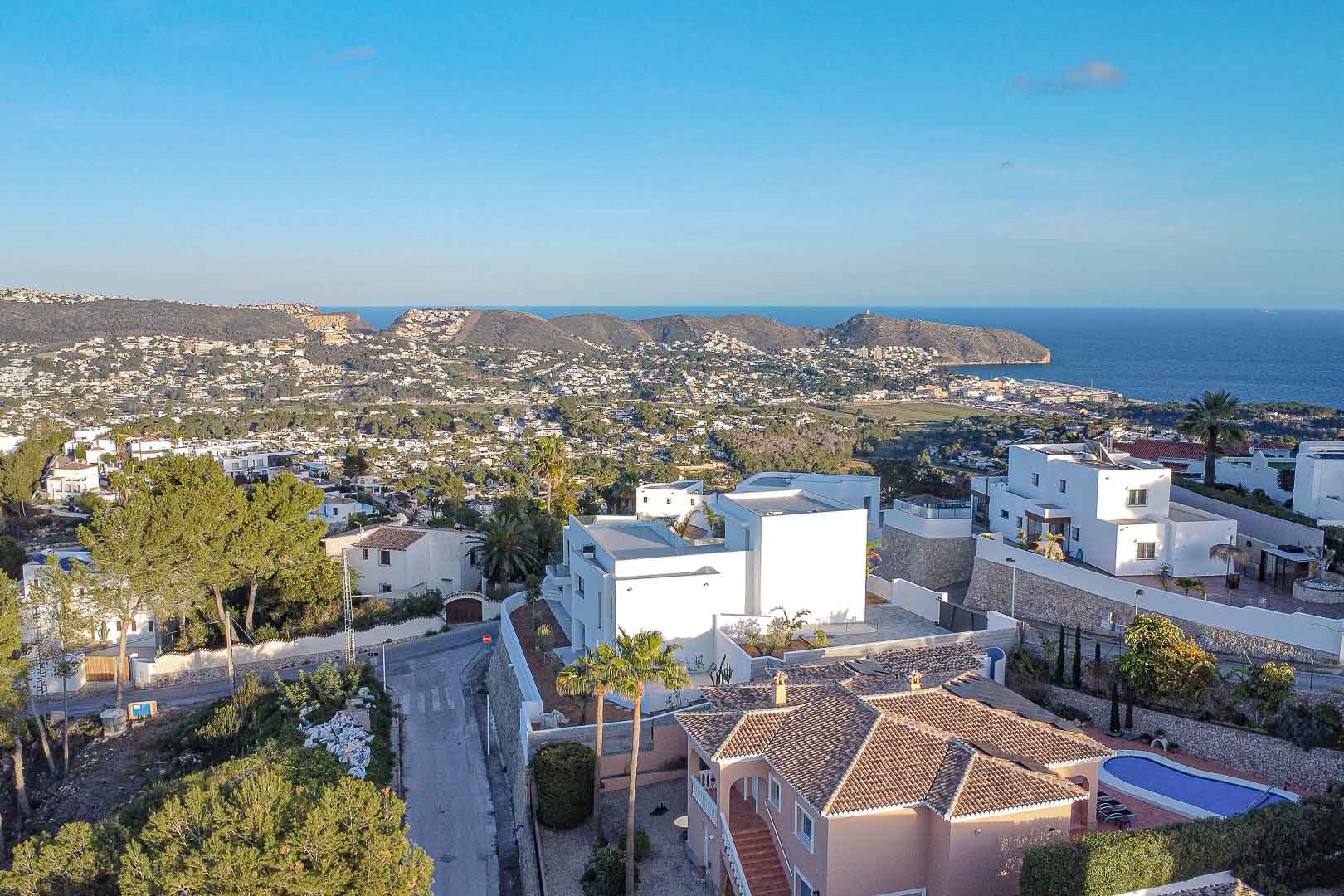 Vista aérea de una villa moderna en Benimeit con vistas panorámicas al mar y a la costa.