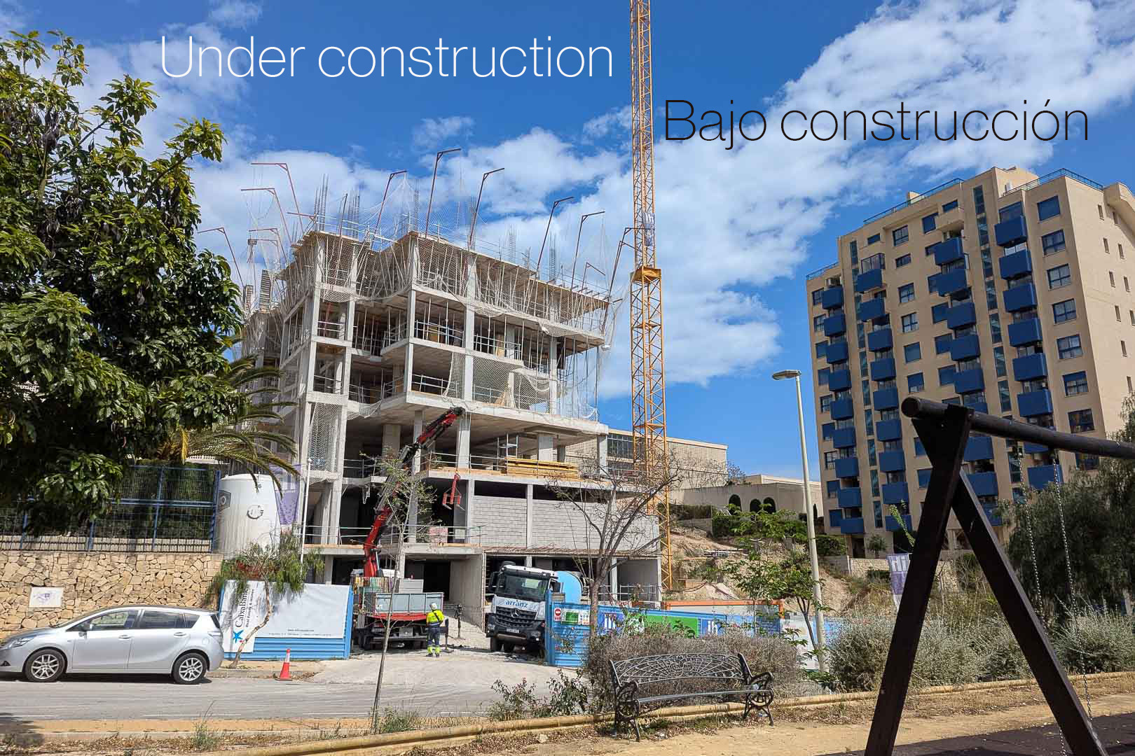 Vista exterior de la fase inicial de construcción en Calpe, mostrando la estructura de hormigón, grúa torre y maquinaria pesada en el solar residencial.