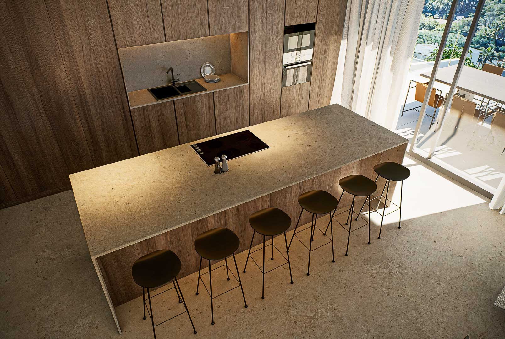Cocina de diseño con isla central en piedra natural, taburetes minimalistas y armarios de madera de suelo a techo. La luz natural inunda el espacio desde la terraza adyacente.
