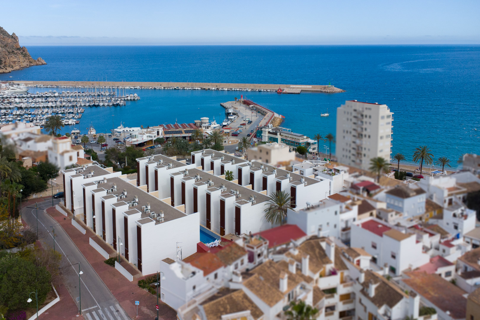 Vista aérea del puerto de Jávea y complejos residenciales modernos junto al mar Mediterráneo, destacando la proximidad de la vivienda a la costa.