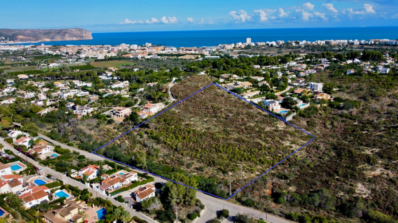 Vista aérea perimetrada de la parcela de 17.272 m² en Jávea, rodeada de zonas residenciales consolidadas y con vistas panorámicas al mar Mediterráneo.