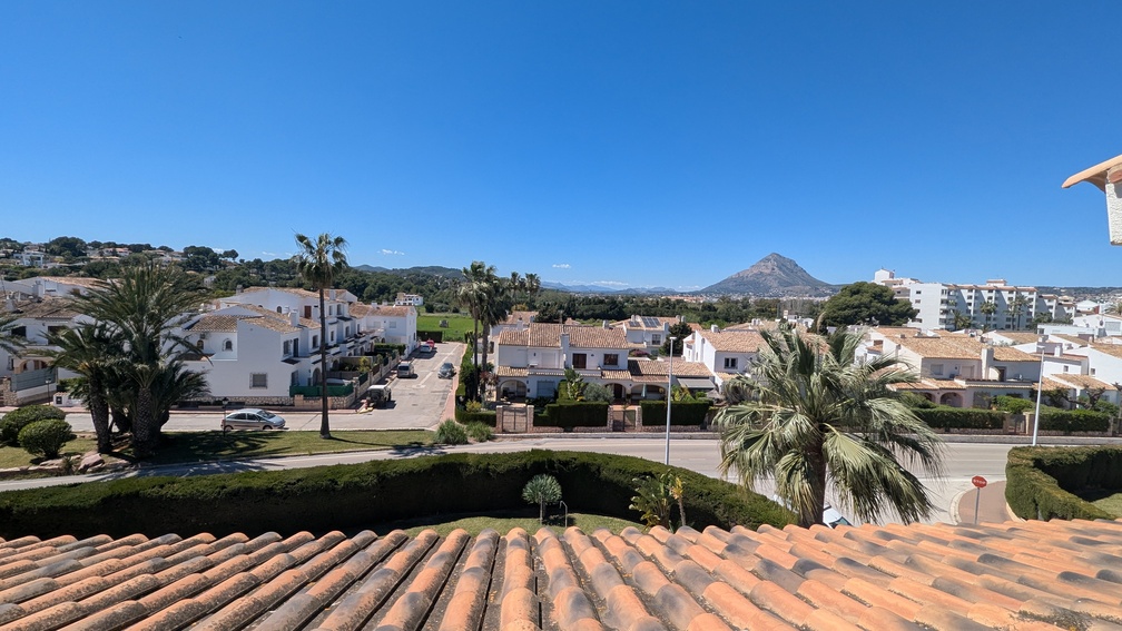 Vistas despejadas desde la terraza hacia el macizo del Montgó, contemplando los tejados de teja cerámica y el entorno residencial de Jávea bajo un cielo despejado.