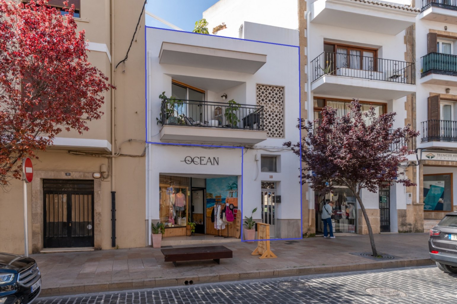 Fachada del edificio reformado con balcón y tienda 'Ocean' en el centro histórico de Jávea.