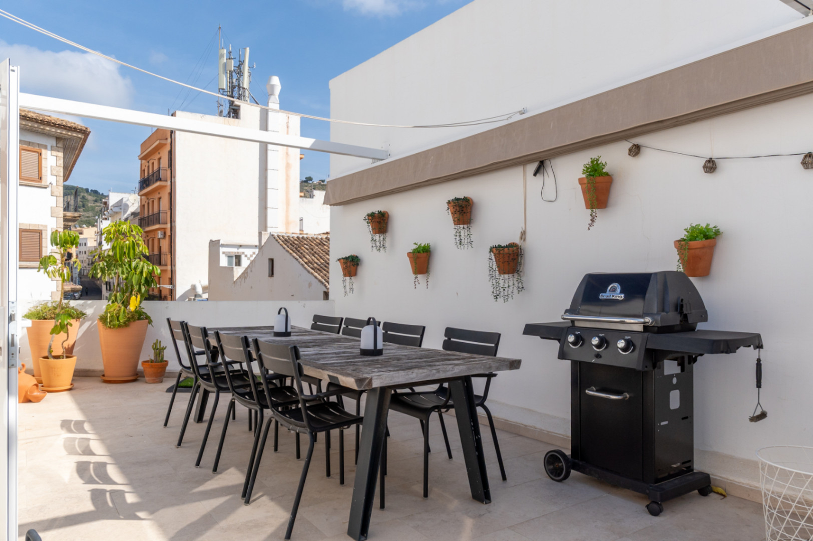 Terraza con comedor exterior, barbacoa y vistas al casco antiguo de Jávea.