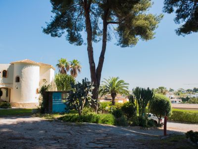 Vista exterior de la villa mediterránea con detalles arquitectónicos únicos y jardines exuberantes.