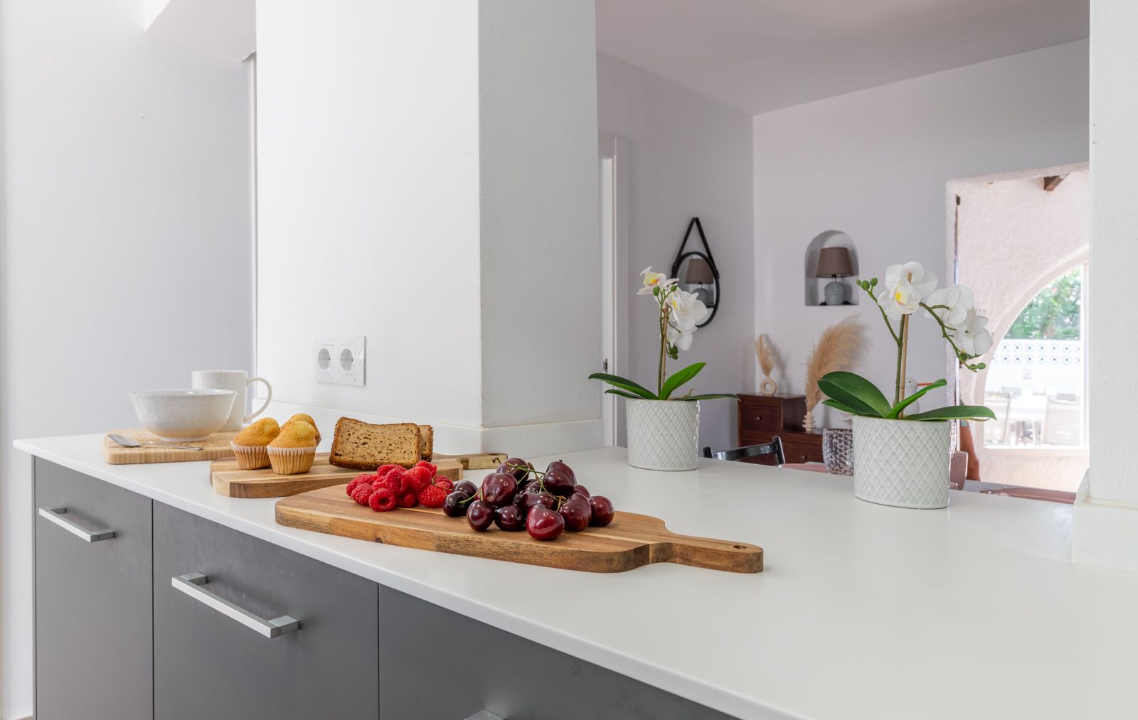 Detalle de la encimera de la cocina con frutales y flores, mostrando un diseño moderno y luminoso. Detalle de la encimera de la cocina con frutales y flores, mostrando un diseño moderno y luminoso.
