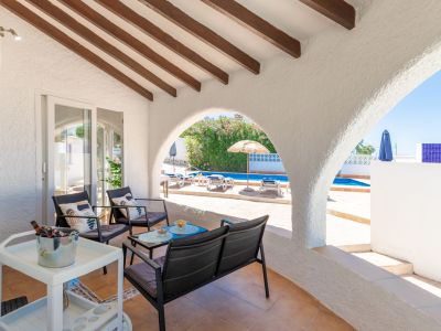 Terraza cubierta con vistas a la piscina y vigas de madera a la vista.