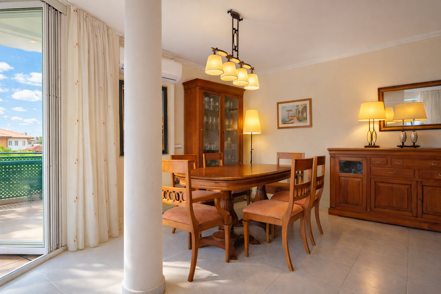 Comedor luminoso con mesa de madera, vitrina y acceso a terraza exterior.