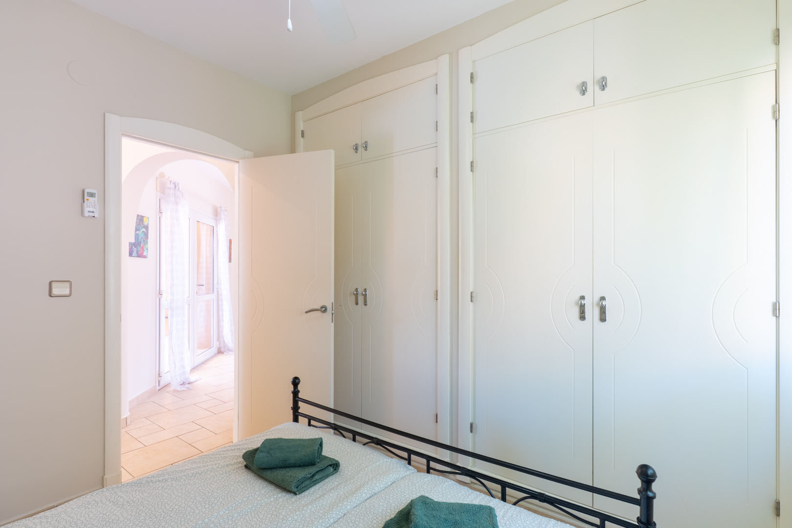 Dormitorio luminoso con armario empotrado de diseño y acceso a terraza.
