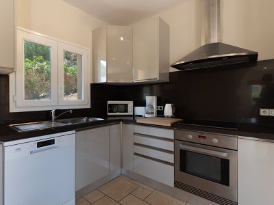 Cocina moderna con encimera negra y electrodomésticos de acero inoxidable.