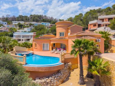 Vista aérea de la villa con piscina azul turquesa y jacuzzi integrado, rodeada de palmeras y jardines.