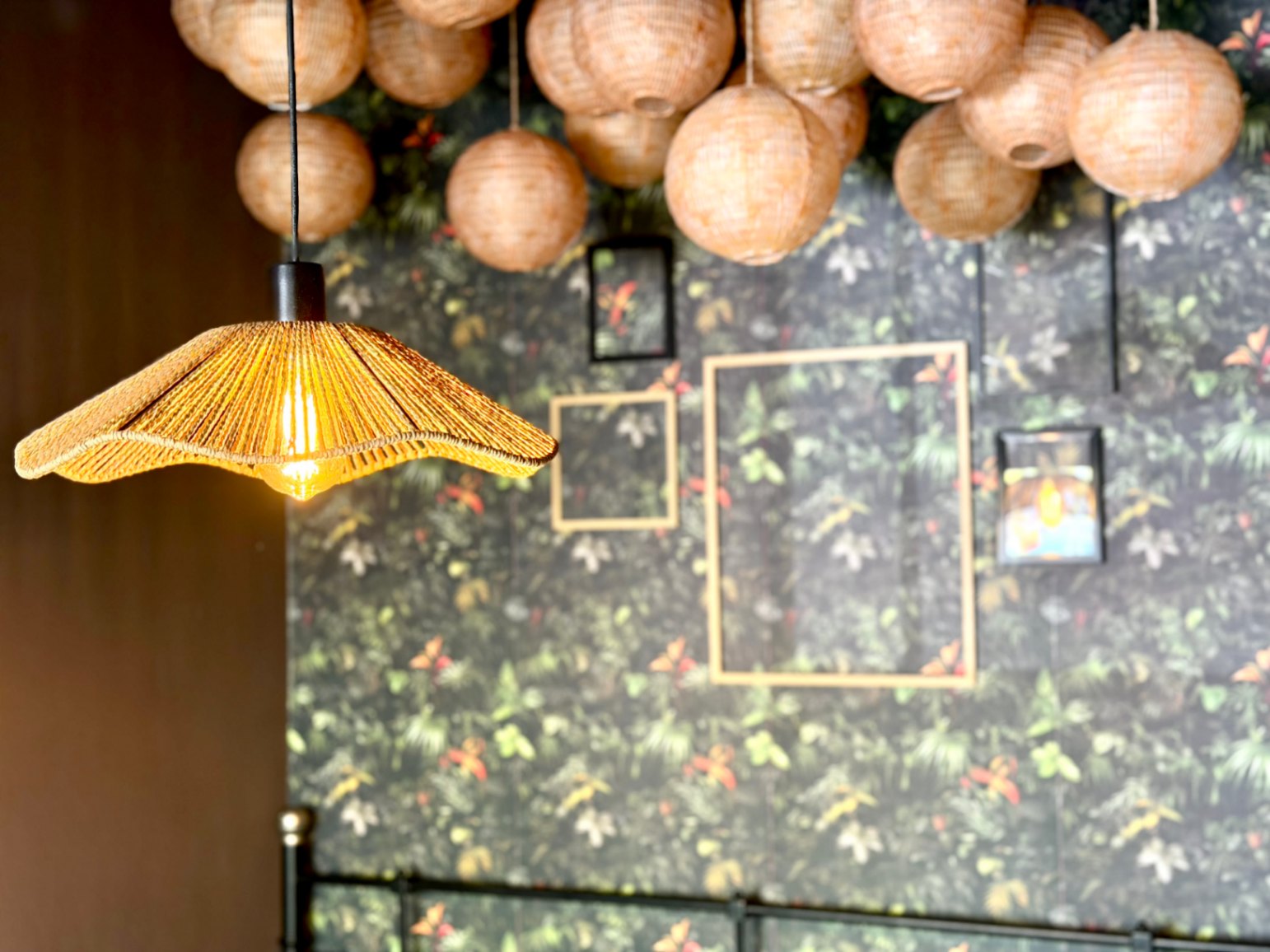 Detalle de lámpara de fibra y decoración floral en pared de dormitorio.