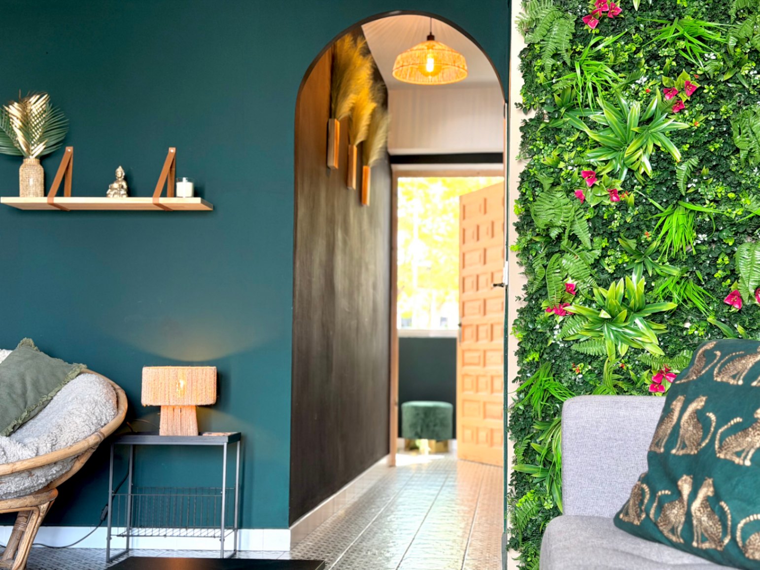 Interior con pared verde vertical, arco decorativo y estantería de madera.