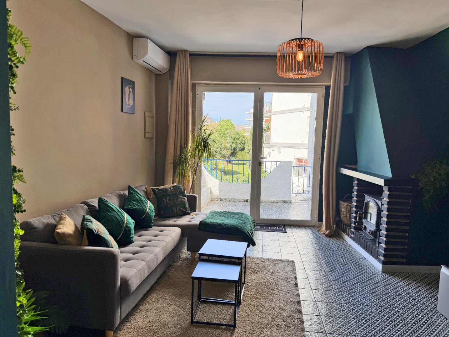 Salón luminoso con chimenea y acceso a terraza con vistas exteriores.