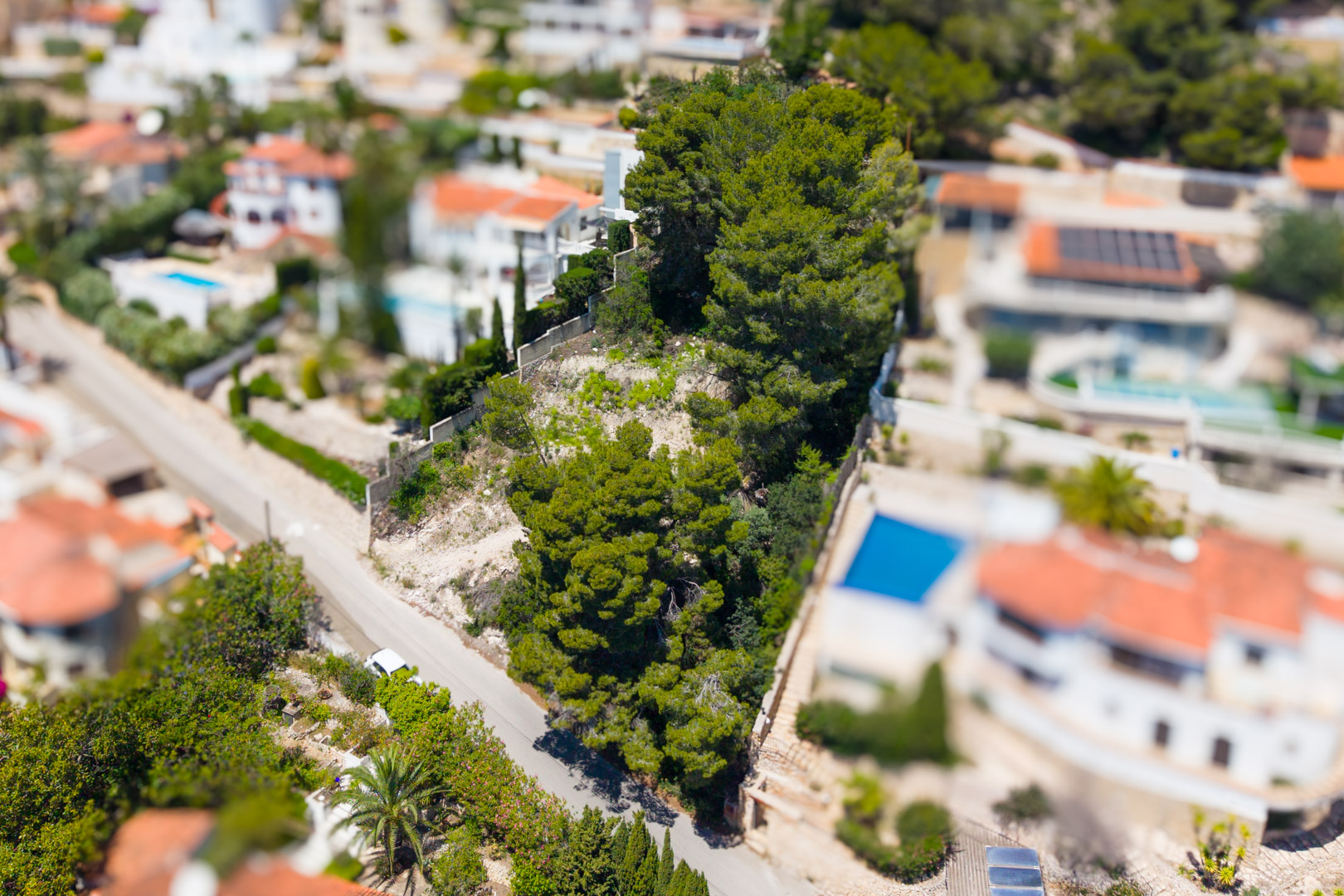Vista aérea de la zona residencial de Montemar con villas, piscinas, densa vegetación mediterránea y carreteras serpenteantes. Vista aérea de la zona residencial de Montemar con villas, piscinas, densa vegetación mediterránea y carreteras serpenteantes.