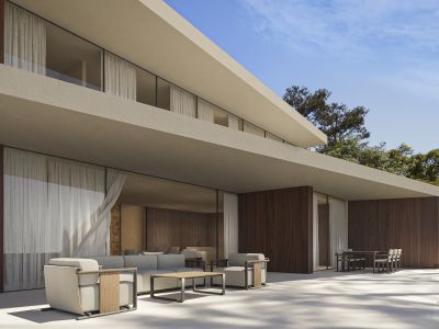 Exterior de villa moderna con amplios ventanales, paneles de madera oscura y terraza de azulejos claros, con zonas de estar y comedor exteriores, rodeada de vegetación.