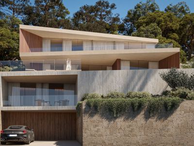 Villa moderna de varios niveles con hormigón claro, detalles de madera y terrazas con barandilla de cristal, integrada en una ladera verde con garaje privado.