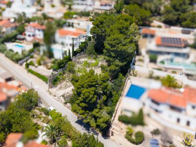 Vista aérea de la zona residencial de Montemar con villas, piscinas, densa vegetación mediterránea y carreteras serpenteantes.
