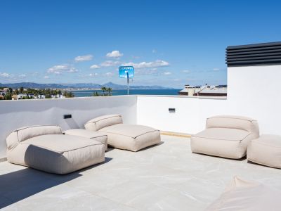 Amplia terraza en la azotea con asientos modulares sobre baldosas claras, ofreciendo vistas panorámicas del mar Mediterráneo y la costa de Dénia.