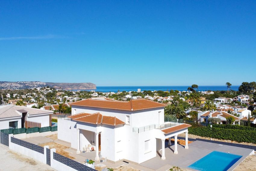 Vista aérea de la villa blanca moderna con piscina privada, terraza cubierta y balcón superior con barandillas de cristal, ofreciendo vistas panorámicas al mar y la costa. Vista aérea de la villa blanca moderna con piscina privada, terraza cubierta y balcón superior con barandillas de cristal, ofreciendo vistas panorámicas al mar y la costa.