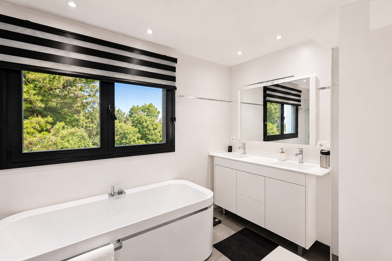 Luminoso baño con ventana de marco negro y vistas al exterior, bañera blanca y tocador doble con espejo.
