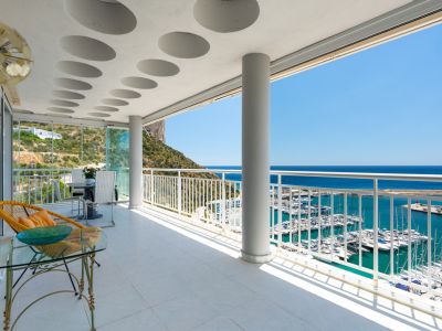 Amplia terraza cubierta con suelo de baldosas claras, techo con detalles circulares y vistas panorámicas al puerto deportivo de Calpe, el mar Mediterráneo y el Peñón de Ifach.