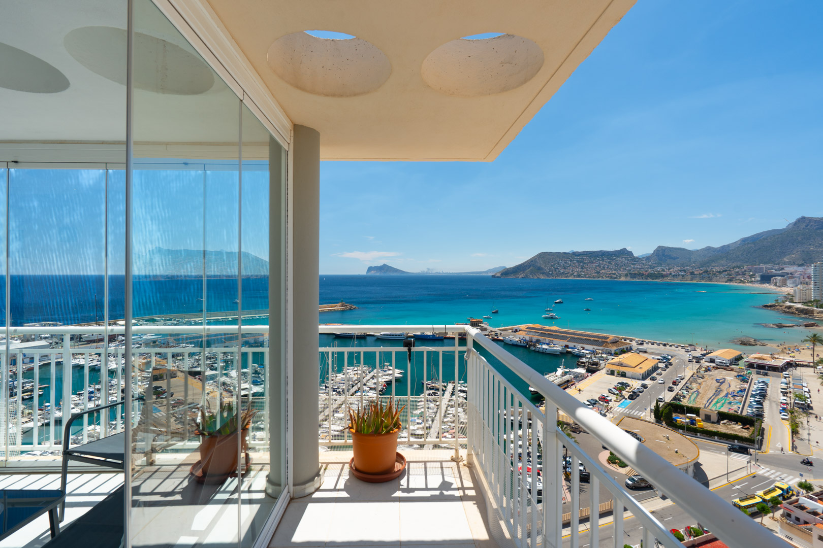 Amplia terraza acristalada con vistas panorámicas al puerto deportivo y la bahía de Calpe, equipada con cortinas de cristal correderas para disfrutar todo el año.
