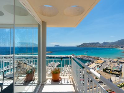 Amplia terraza acristalada con vistas panorámicas al puerto deportivo y la bahía de Calpe, equipada con cortinas de cristal correderas para disfrutar todo el año.