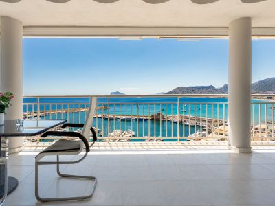 Amplia terraza cubierta con suelo de baldosas blancas, ofreciendo vistas frontales al puerto deportivo de Calpe y al mar Mediterráneo bajo un cielo despejado.