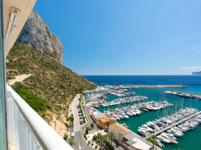 Vistas panorámicas desde la terraza, abarcando el majestuoso Peñón de Ifach, el vibrante puerto deportivo de Calpe con sus embarcaciones y el azul intenso del Mediterráneo.