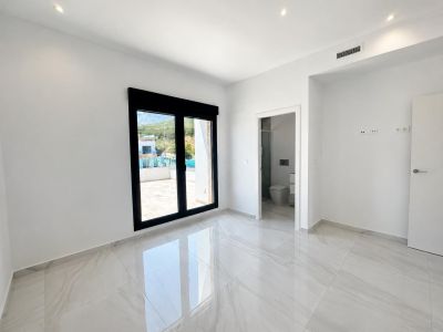 Amplio dormitorio con suelo de gres porcelánico brillante, acceso directo a la terraza exterior y baño en suite. Incluye iluminación empotrada y preinstalación de aire acondicionado.